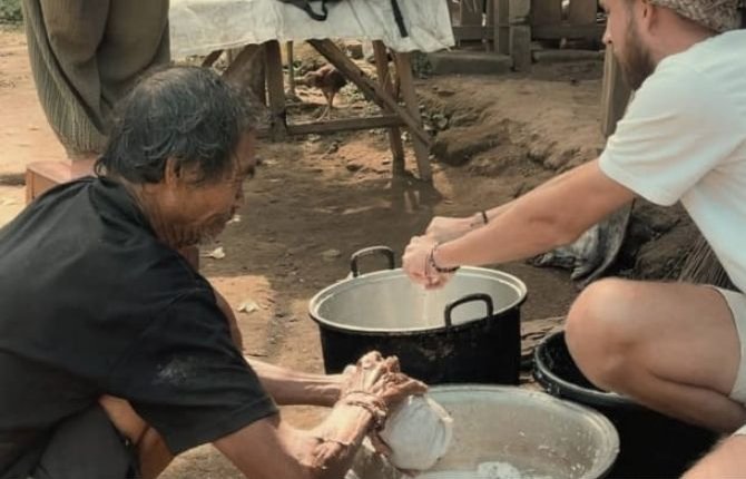 Guest learning traditional coconut oil pressing from a Balinese local